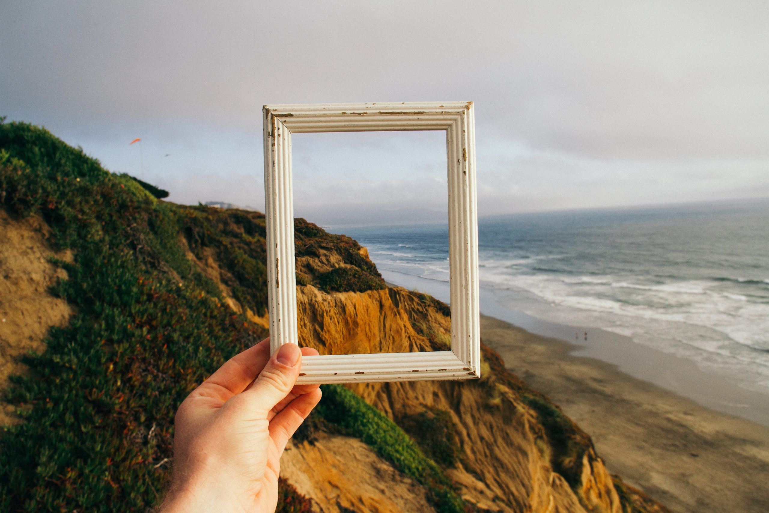 hand holding a picture frame in front of vista